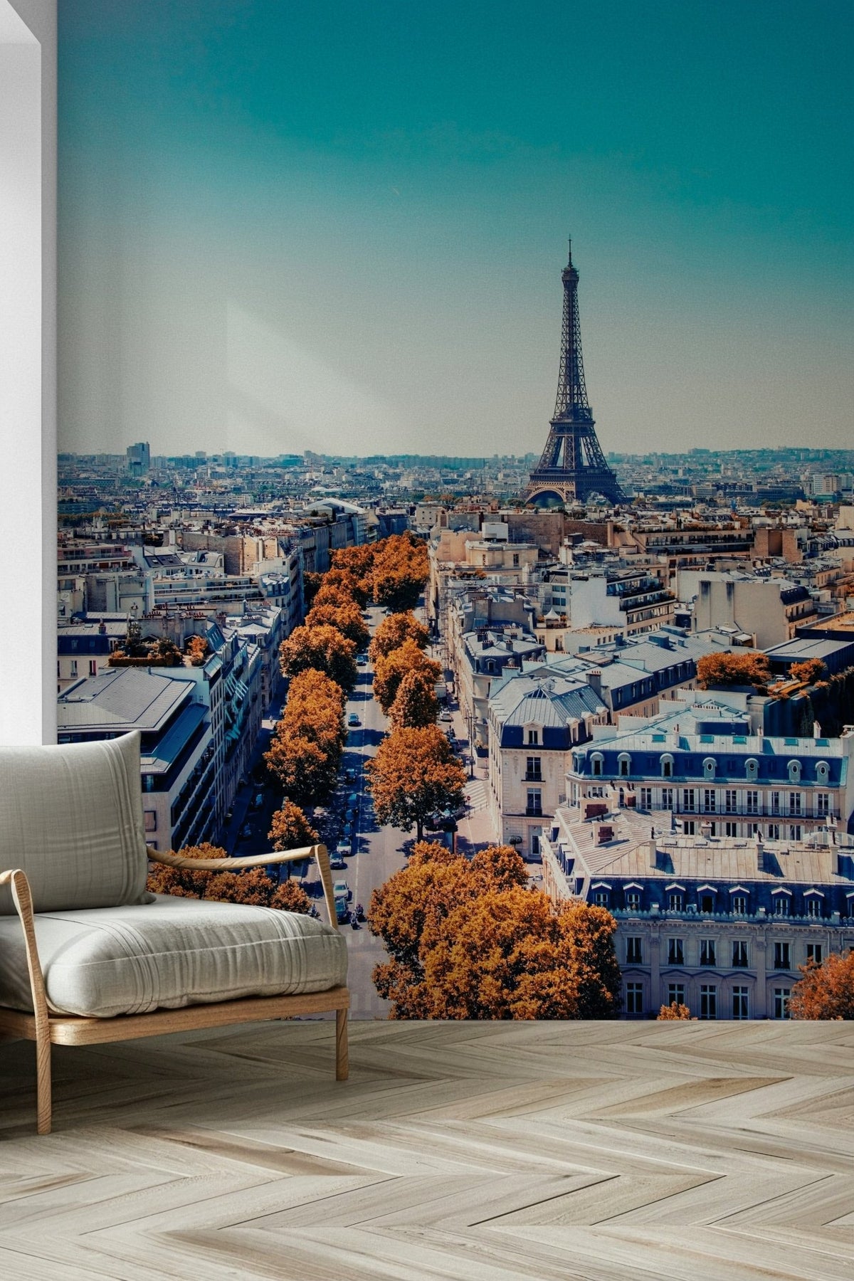 Fall in Paris wallpaper mural of the Eiffel Tower and autumn skyline behind a white armchair in a living room
