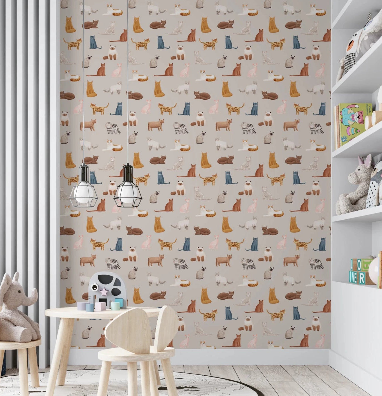 Feline Friends Forever wallpaper with illustrated cats on beige in a kids playroom with a wooden table and plush toys