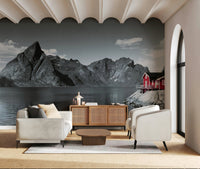 Fjord Home wall mural featuring towering dark mountains rising above a calm fjord with a red cabin on the shore.