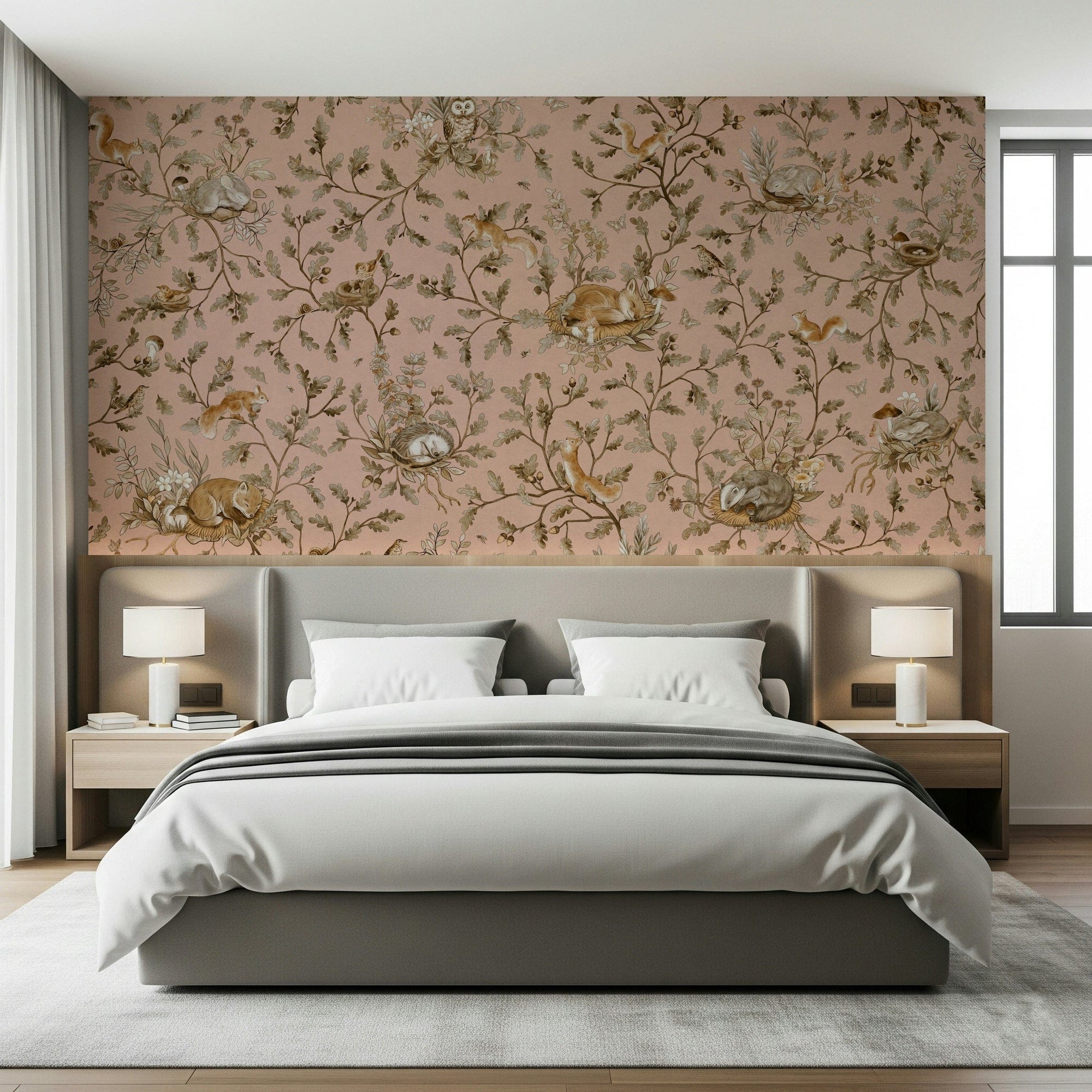Forest Nap wallpaper mural in soft pink above a grey upholstered bed with white nightstand lamps in a bedroom