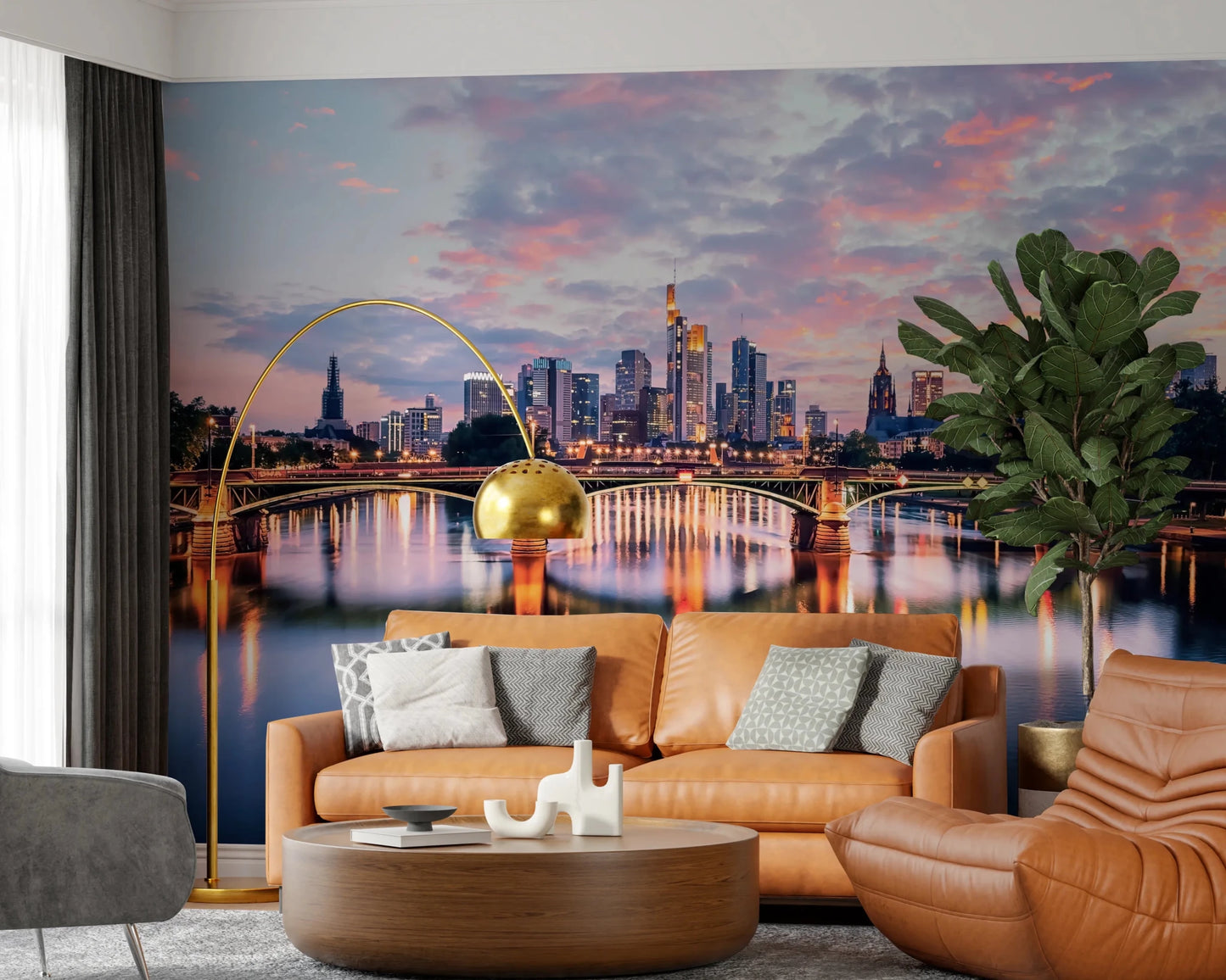 Frankfurt Dawn wallpaper mural of the glowing skyline and river behind a tan leather sofa and gold arc lamp