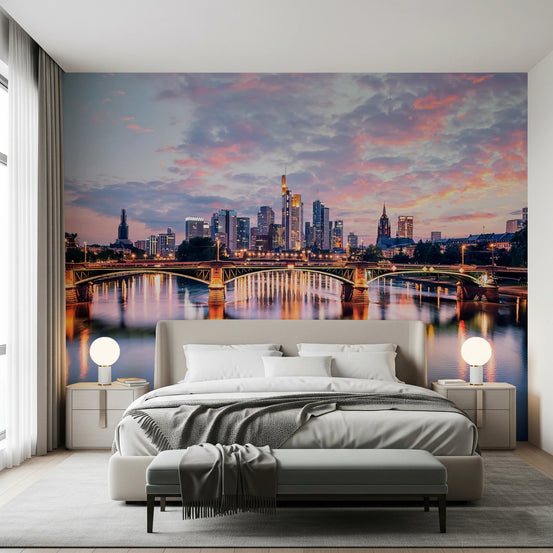 Frankfurt Dawn wallpaper mural of the sunset skyline and lit river bridge behind a grey bed in a bedroom