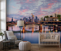 Frankfurt Dawn wallpaper mural with purple sunset sky over the river behind a white crib in a nursery