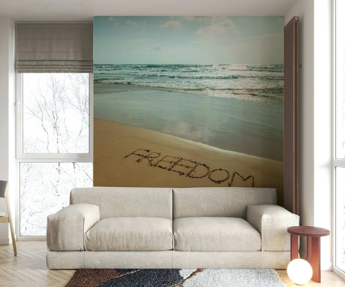 The image shows a full wall with the word "FREEDOM" written in the sand.

