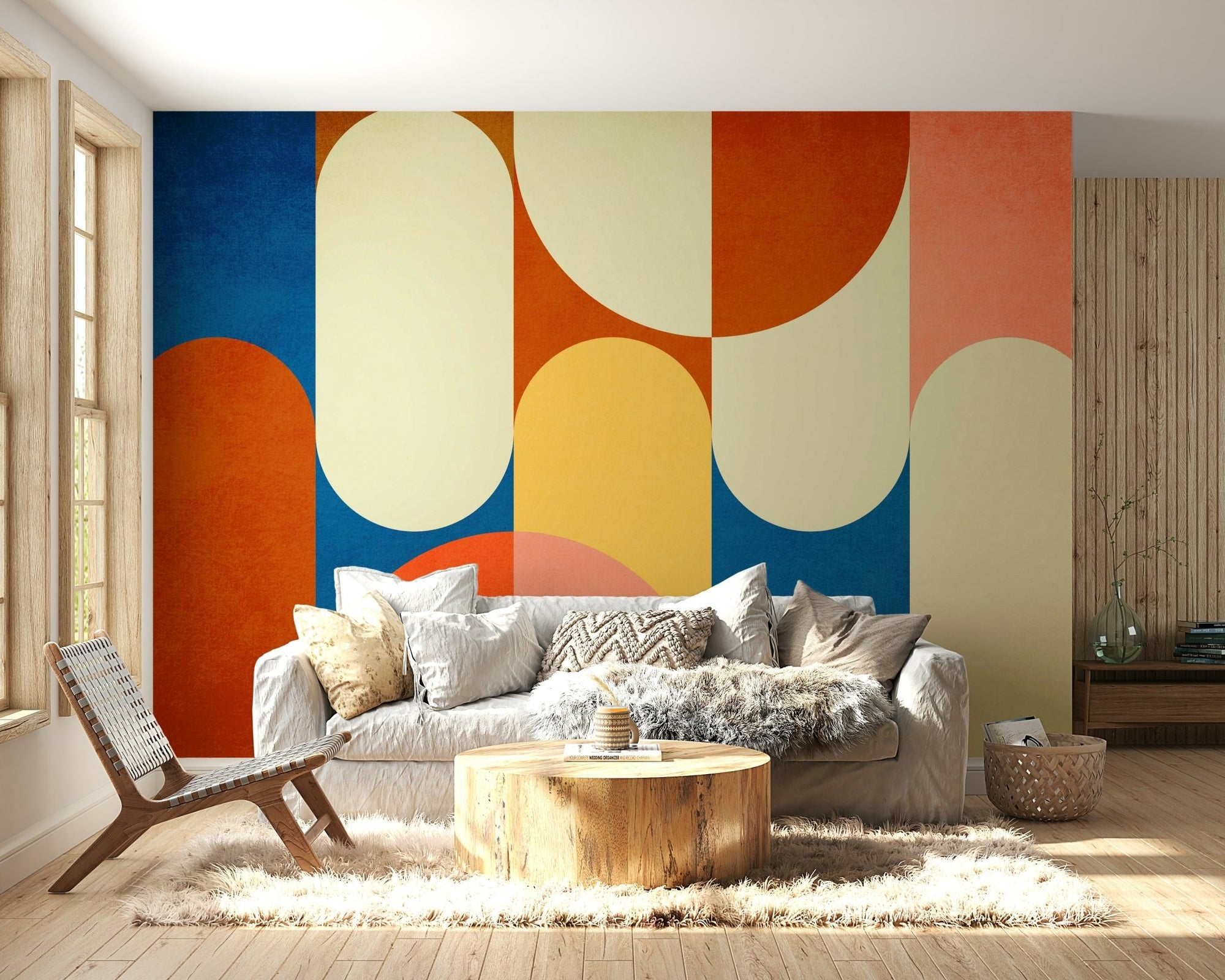 Frodo wallpaper mural with bold retro geometric arches in blue and orange behind a white sofa in a living room
