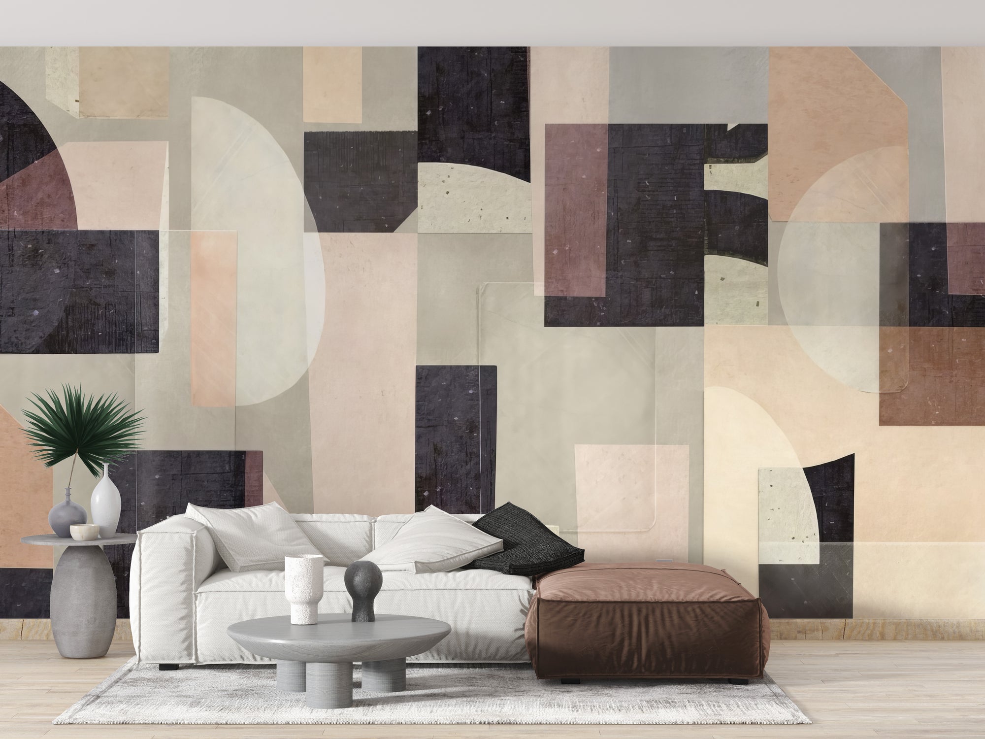 Modern Abstract wallpaper mural in earthy beige and charcoal geometric shapes behind a white sofa and brown leather pouf in a living room