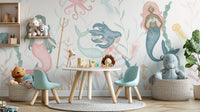 Dreamy Aquatic Ballet wallpaper of pastel mermaids and sea creatures behind a round play table in a kids room