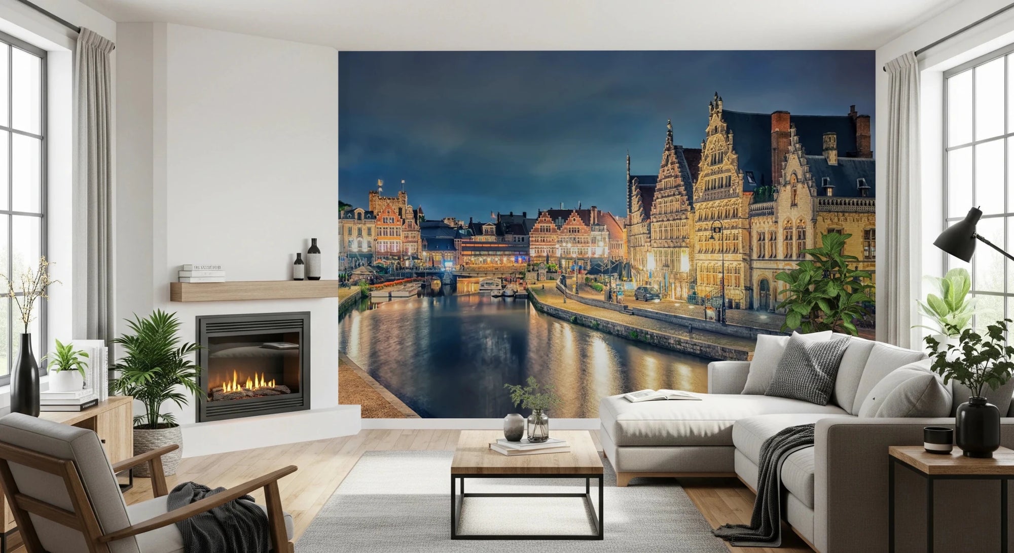 Ghent Lights wallpaper mural of an illuminated canal and medieval guild houses behind a white sectional sofa and fireplace in a living room
