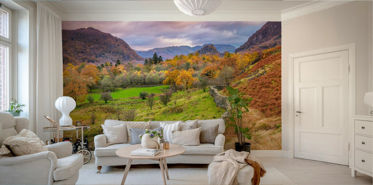 Golden Hills wallpaper mural of an autumn valley with green meadow and rugged hills at dusk behind a beige sofa in a living room