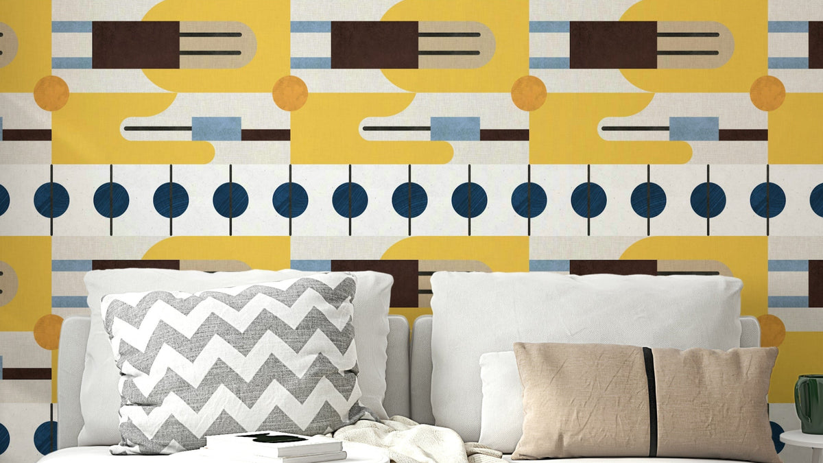 Golden Hour Hues wallpaper in bold mustard, navy and brown geometry above a sofa with grey chevron pillows