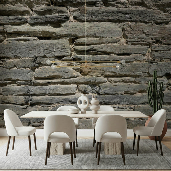 Grey Stone Layers wallpaper mural behind a cream dining table and chairs with a gold pendant in a dining room