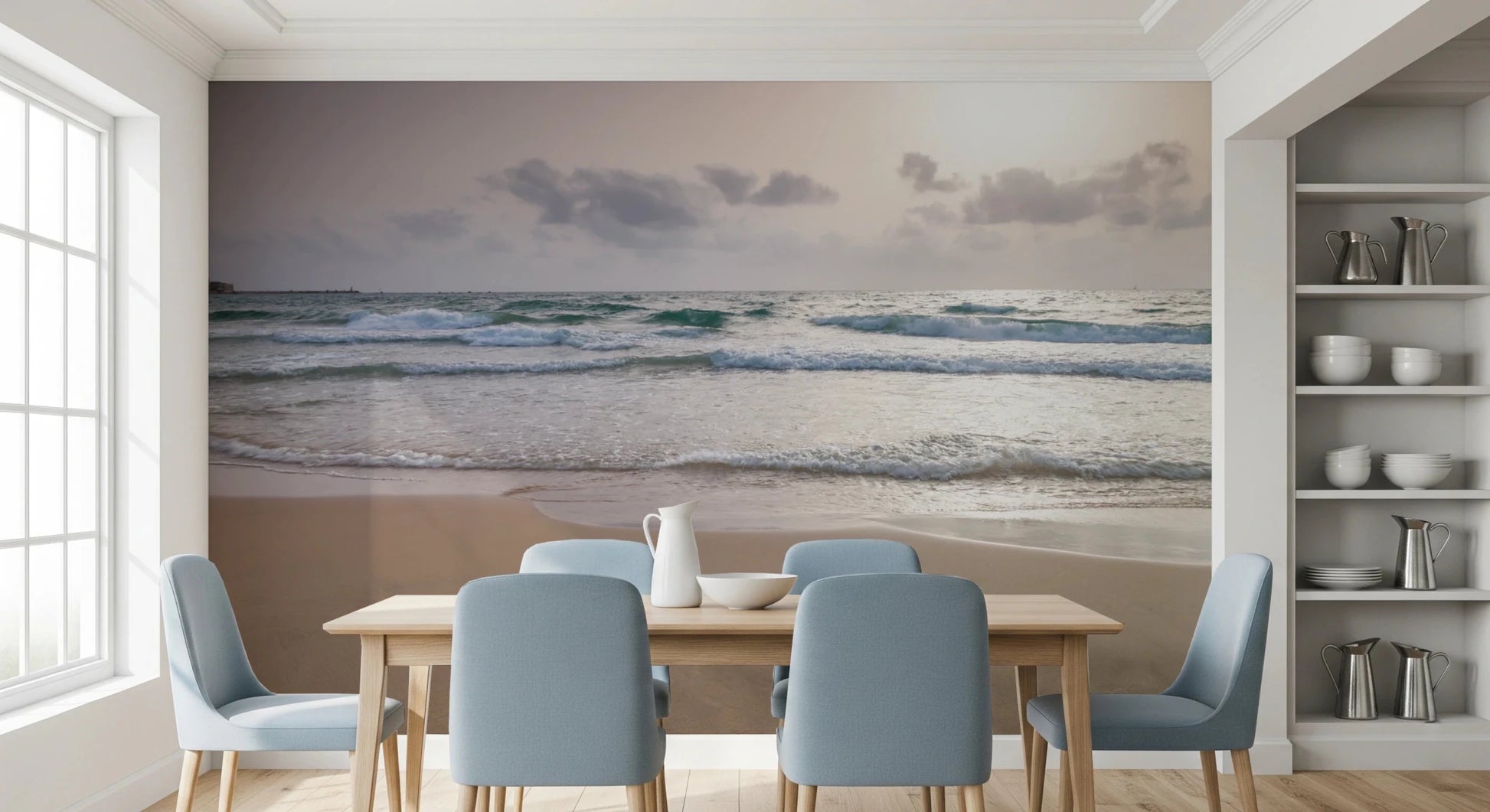 Happy Beach Vibes wallpaper mural of soft ocean waves behind a wood dining table with light blue chairs