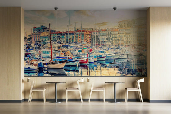 Harbor Serenity wallpaper mural of moored sailboats and pastel waterfront houses above wood chairs and tables in a cafe