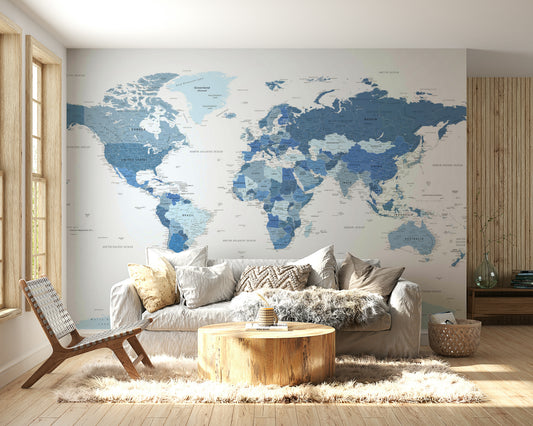 Highly Detailed World Map in Blue wallpaper mural behind a white sofa, log coffee table and woven lounge chair in a living room