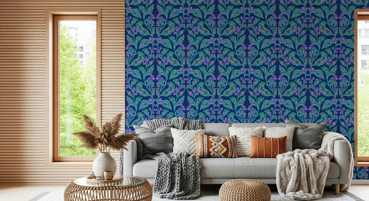 Indigo electric leaves wallpaper of teal and purple botanical motifs behind a grey sofa with knit cushions