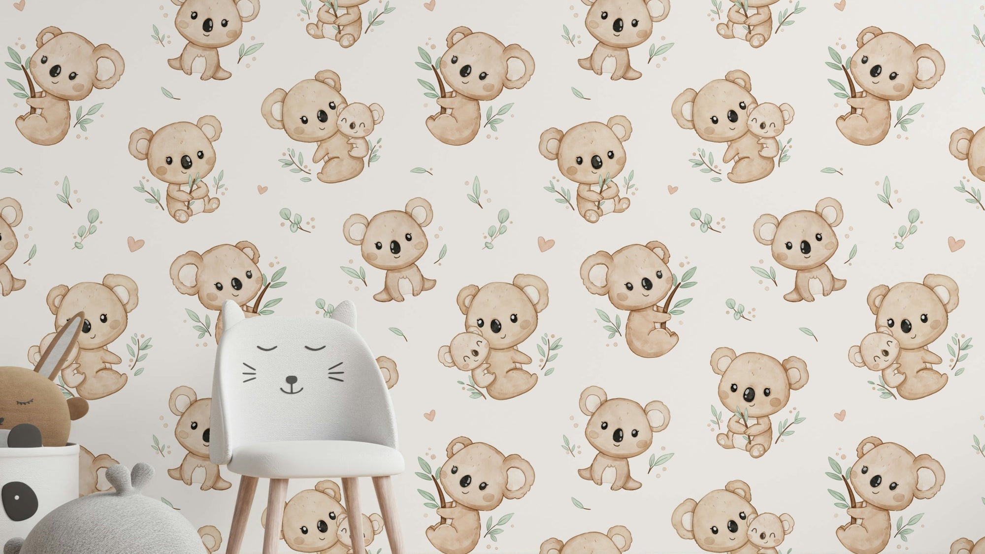 Koala Cuddles wallpaper in cream behind a white cat-ear chair with plush toys in a child's room
