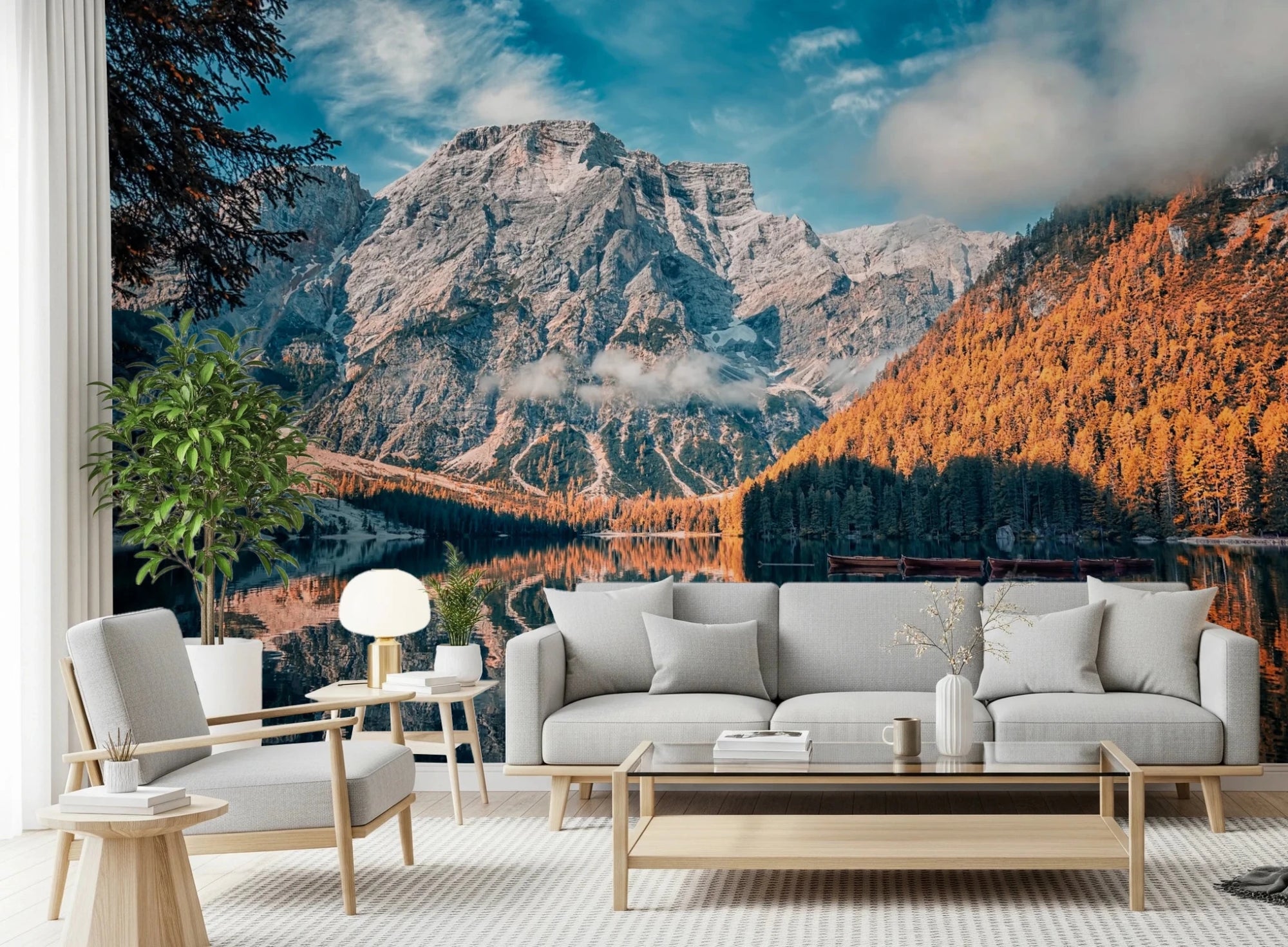 Lake Braies Serenity wallpaper mural with grey Dolomite peak and autumn forest behind a grey sofa and armchairs in a living room