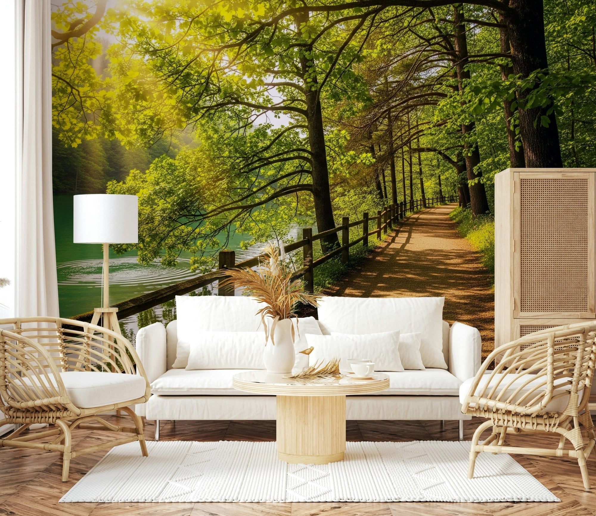 Lake Path Serenity wallpaper mural of a green forest trail by a lake behind a white sofa and rattan chairs in a lounge