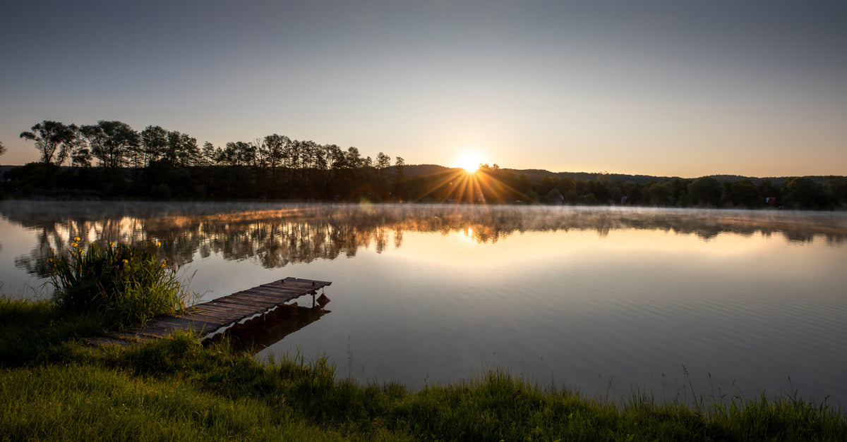 Tranquil Sunrise Reflection Over Serene Lake Wall Mural in your room