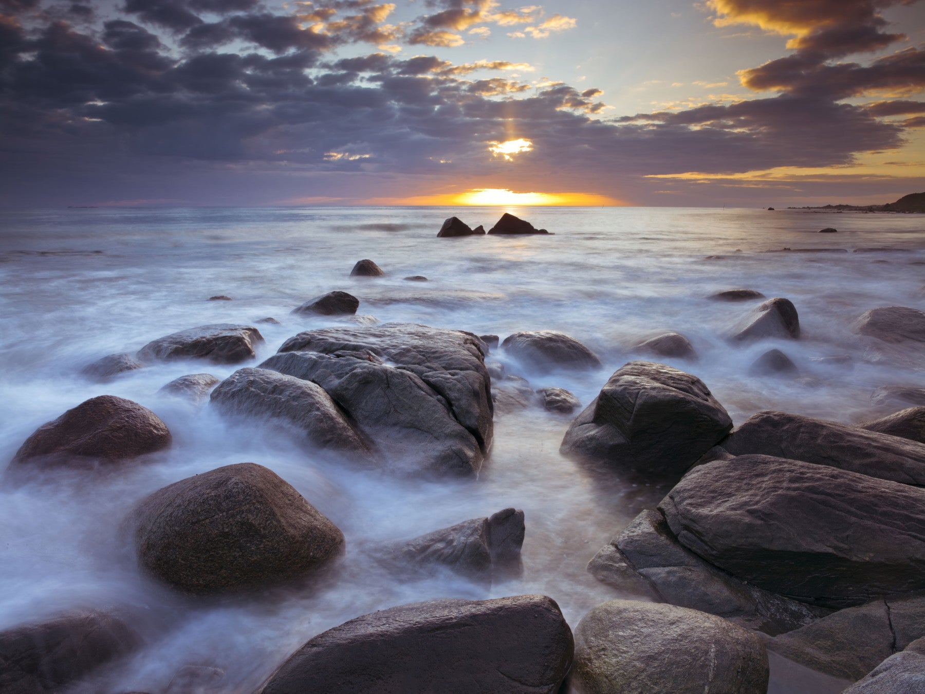 Sunset coastal scene spreading across a café seating area as a wall mural