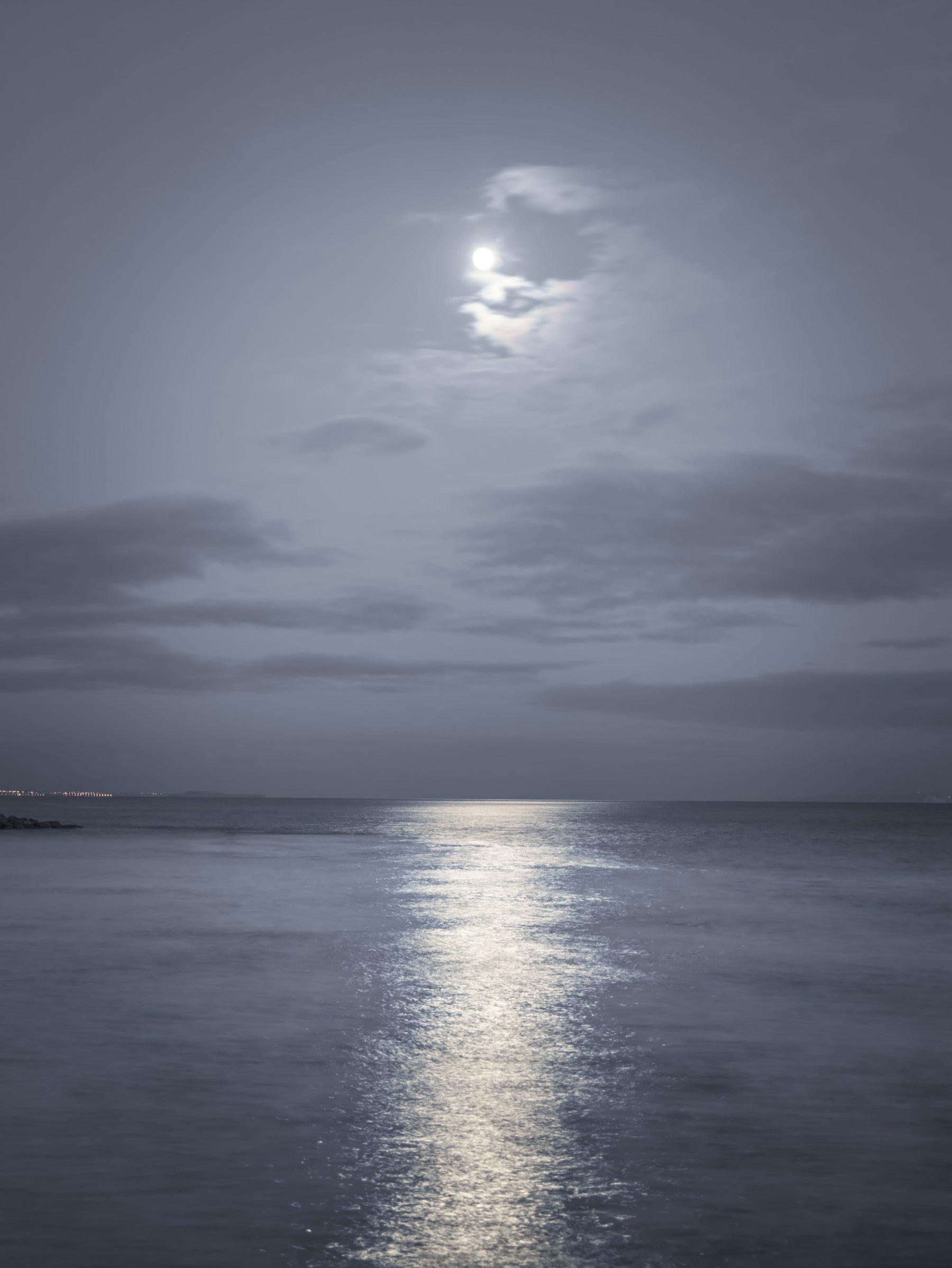 Moonlit Ocean Serenity wall mural set behind a bed in a deep blue bedroom