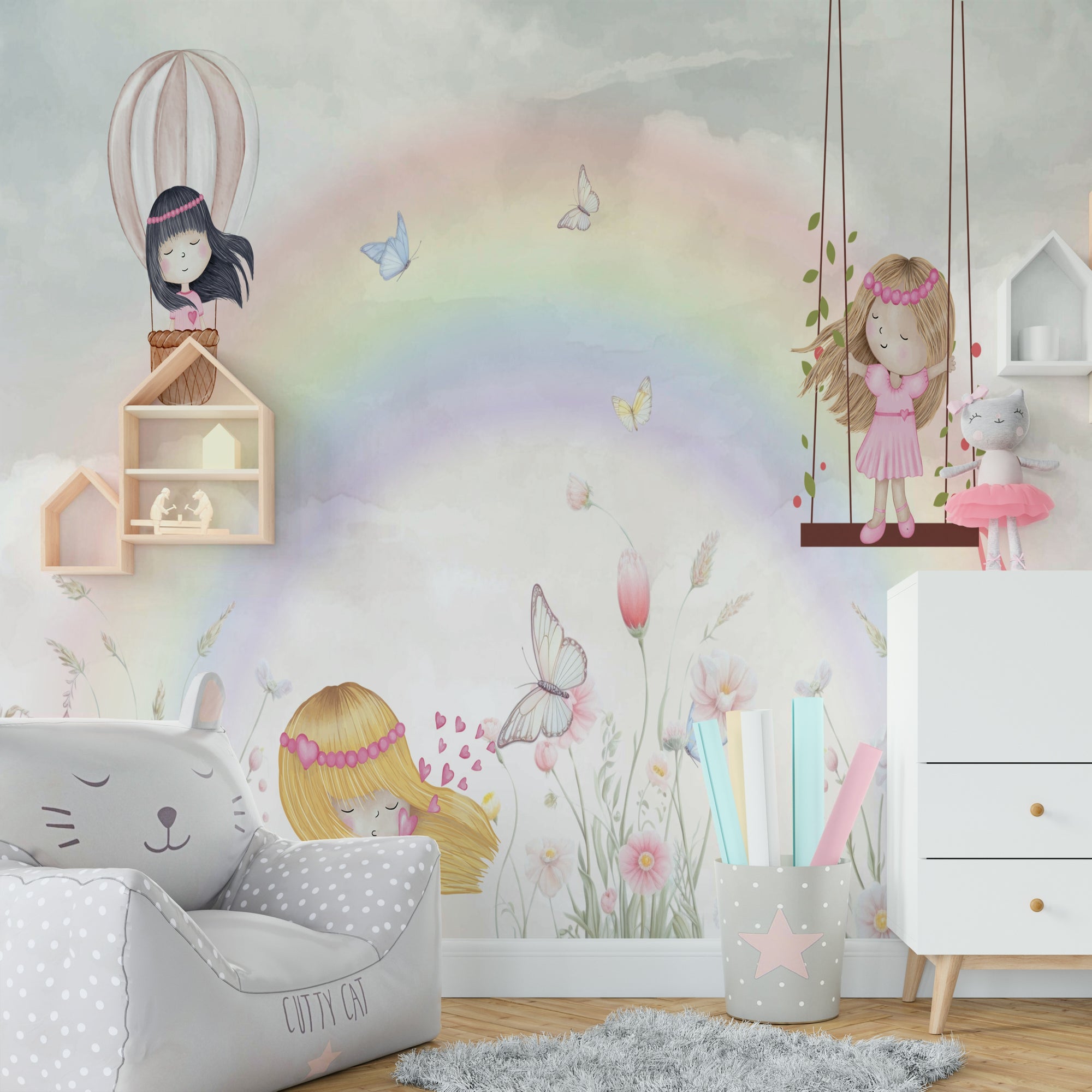 Little Girls Adventures wall mural with a pastel rainbow and fairies above a gray cat beanbag chair in a kids room