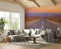 Peaceful sunset over a long highway with a desert landscape in the mural.

