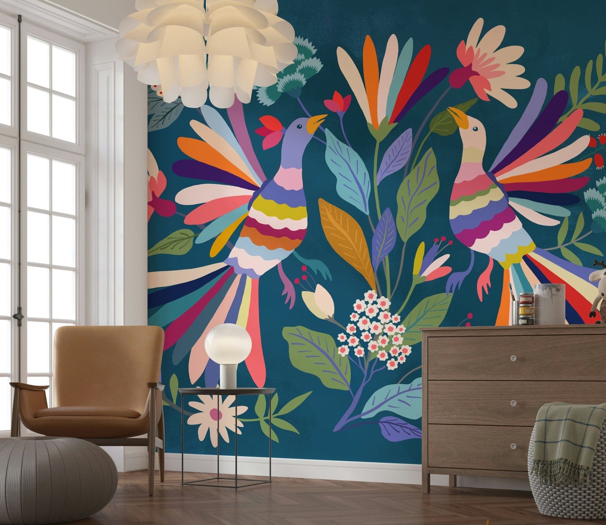 Love Birds mural on teal behind a tan armchair and wooden dresser in a sunlit living room