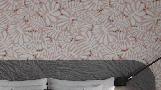 Whimsical Blush Botanical wallpaper in pink with white florals above a grey upholstered bedroom headboard