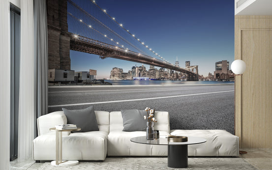 Manhattan Cityscape wallpaper mural of the Brooklyn Bridge at dusk above a white sofa with grey pillows