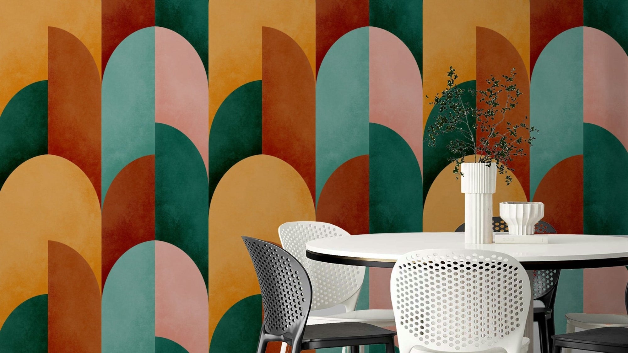 Mid Mod Geometry Sunburn wallpaper mural in orange, teal and pink arches behind a white round dining table and chairs