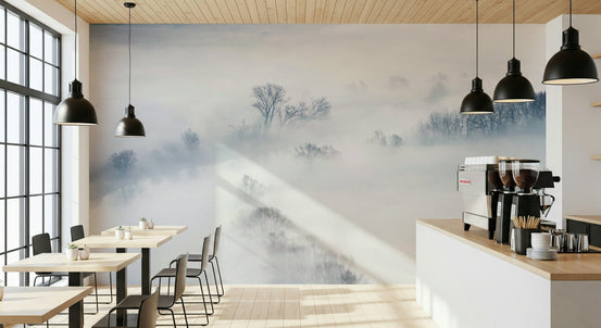 Misty Treescape wallpaper mural of foggy winter trees behind small wood cafe tables and a coffee bar with pendant lamps