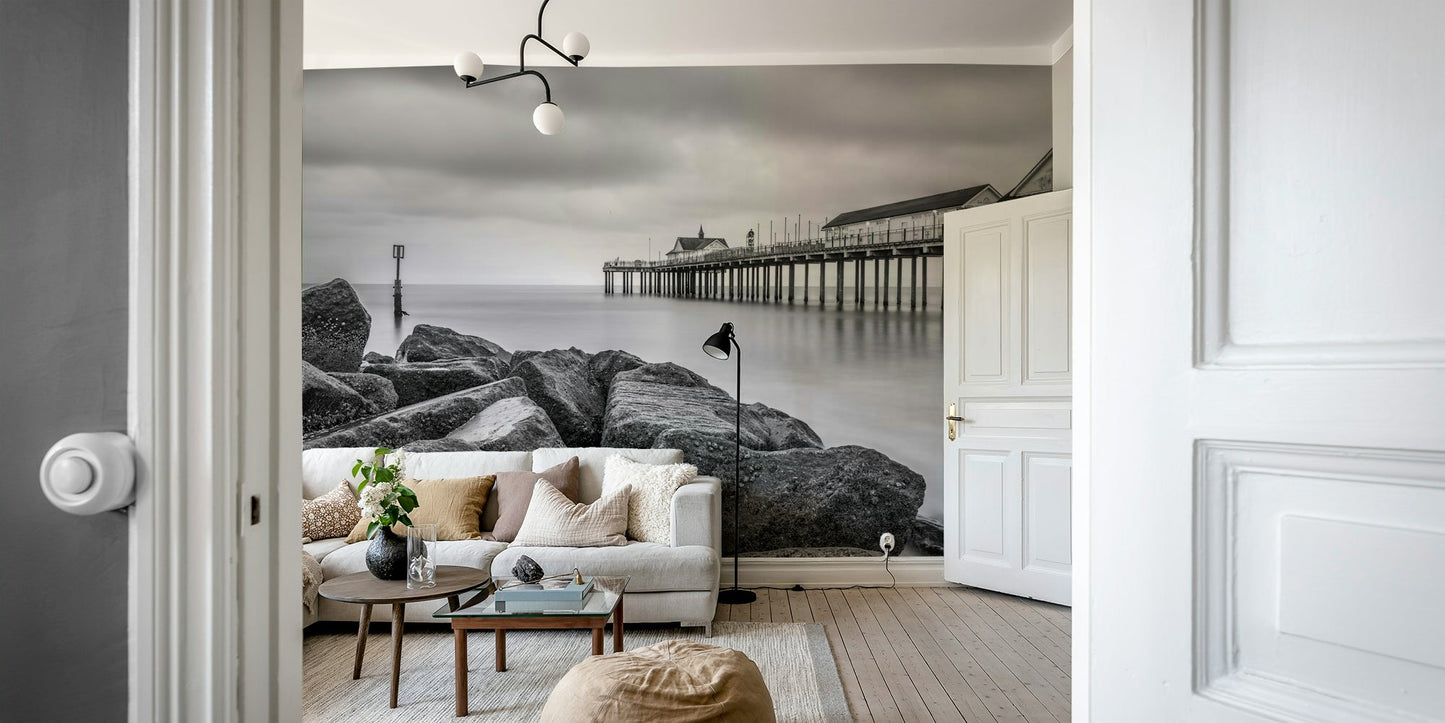 Features a long pier extending into calm, reflective water.
