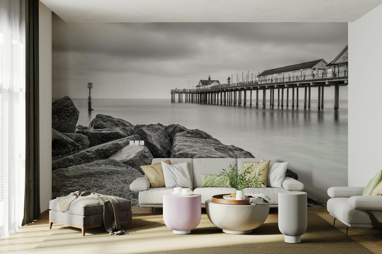Rugged, textured rocks are prominent in the foreground, leading the eye towards the pier.
