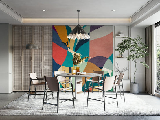 Mosaic Flora wall mural of bold abstract leaves behind a round marble dining table and chairs in a dining room