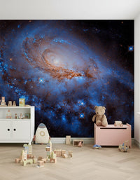 Nebula Dreams wall mural of a glowing spiral galaxy behind a white cabinet, teddy bear and toy chest in a kids room