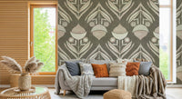Stylized botanical pattern with symmetrical blooms and curved leaves in muted tones over a textured gray base