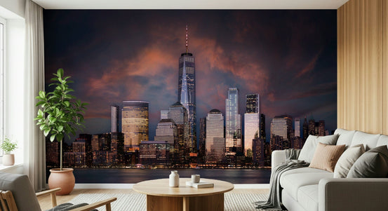 New York Twilight wallpaper mural of the Manhattan skyline at dusk behind a white sofa in a living room