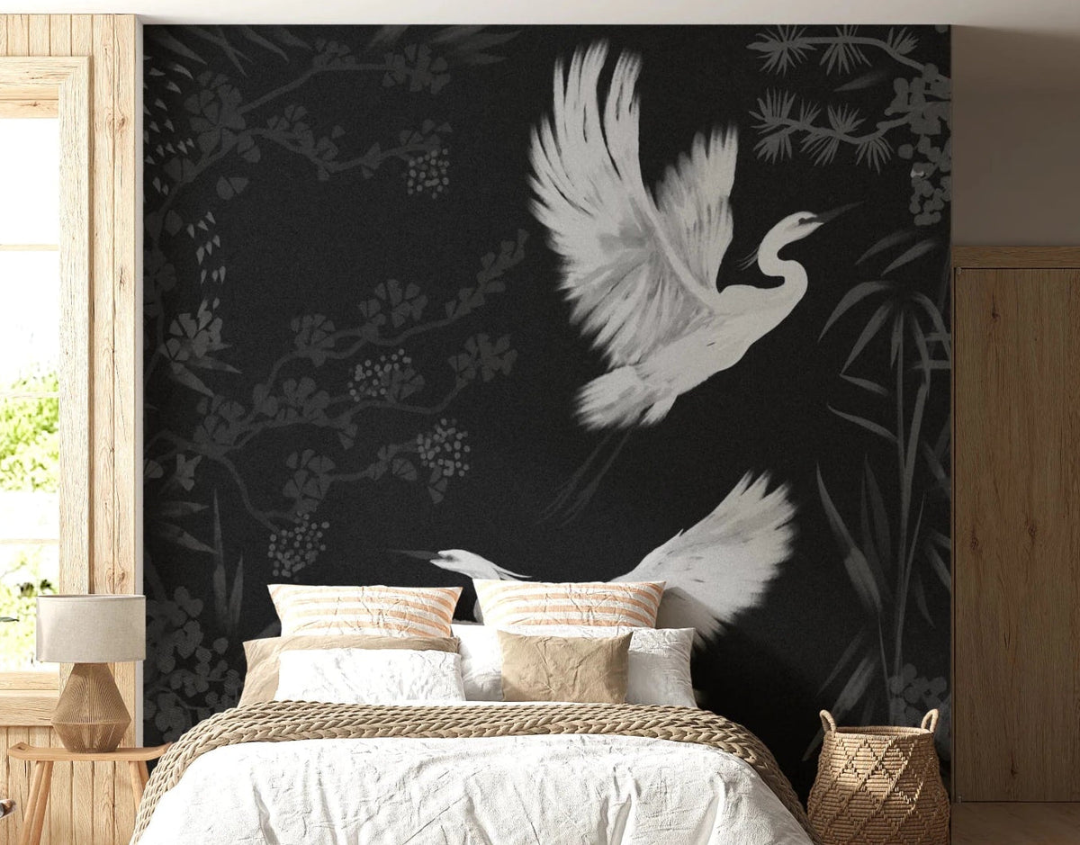 Night Heron's Grace wallpaper mural with two white herons in flight on black behind a white bed in a bedroom