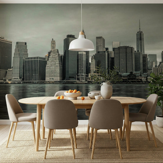 NYC Skyline wallpaper mural of Manhattan skyscrapers across the water behind a wooden dining table with taupe chairs