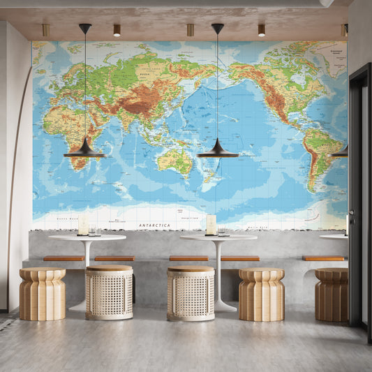 Pacific View Detailed World Map wallpaper mural in blue and green behind white bistro tables and rattan stools in a cafe
