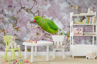Bright parakeet with pink flowers in a spring floral wallpaper.


