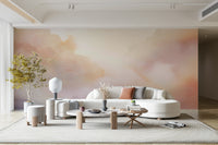 Pastel Cloud Dreamscape Wall Mural behind a gray velvet sofa in a bright living room.