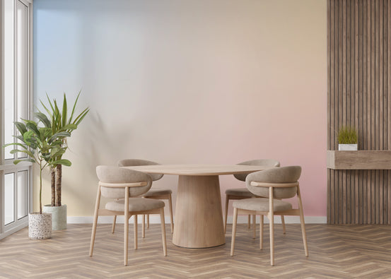 Pastel gradient dreamy abstract wallpaper mural in blue and pink behind a round wood dining table and chairs