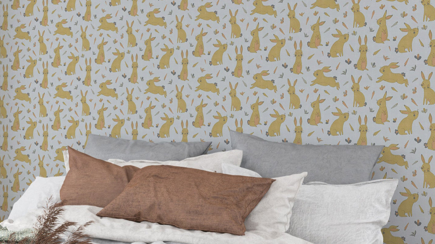 Bunnies and Rabbits Golden Gray wallpaper over a bed with gray pillows and brown cushion in a bedroom