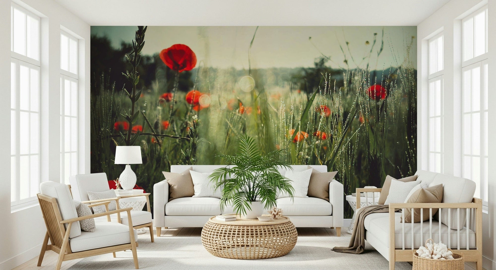 Meadow Dew mural of red poppies in dewy grass behind a white sofa and rattan table in a bright living room