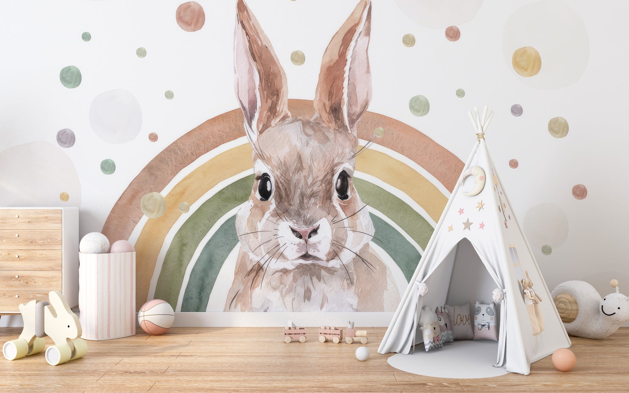 Rainbow Rabbit Nursery wallpaper mural of a watercolor bunny and pastel rainbow beside a white teepee in a kids room