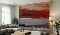 Earthy tones abstract landscape wall mural behind a grey sofa in a studio.