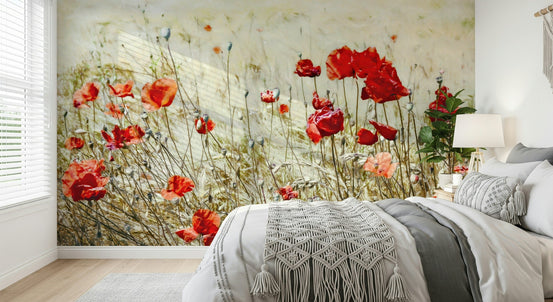 Scarlet Bloom Meadow wallpaper mural of red poppies in a cream field behind a grey and white bed with a macrame throw