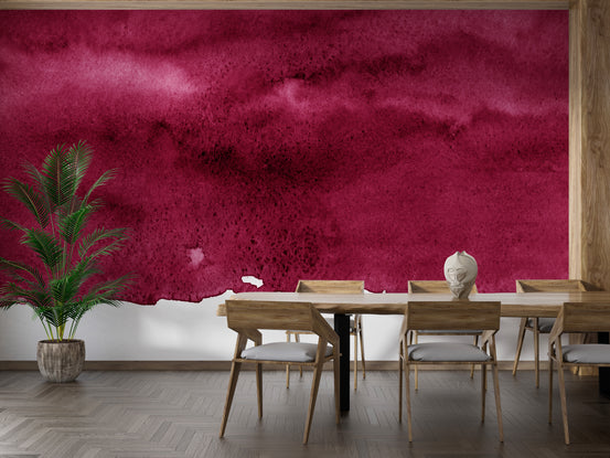 Red Wine Maroon Watercolor wallpaper mural in magenta tones in a dining room with a wood table and potted palm